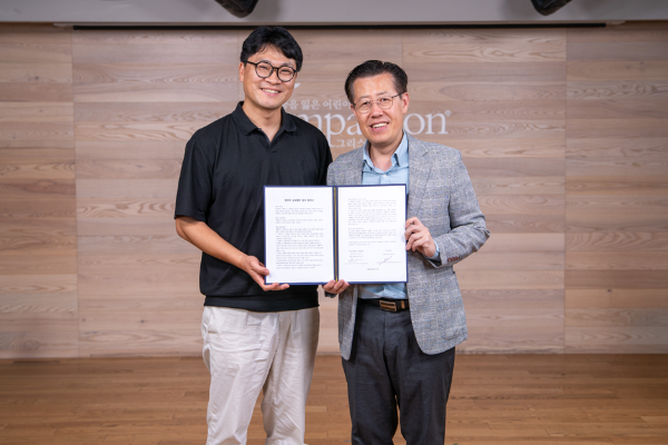 협약식에서 팩애드 장진환 대표(왼쪽)와 컴패션 전두위 본부장이 기념 촬영을 하고 있는 모습