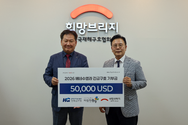 한미글로벌 최성수 사장(왼쪽)이 희망브리지 신훈 사무총장과 베네수엘라 지원을 위한 성금 기탁식 진행 후 기념사진 촬영을 하고 있다.