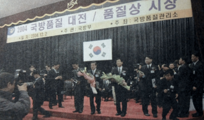 넥스원퓨처 임직원들이 2004년 12월 2일 국방부 주관으로 열린 ‘제1회 국방품질상’ 시상식엣서 대기업 부문에서 영예의 대상을 수상한 뒤 기념촬영을 하고 있다. 사진= LIG D&A
