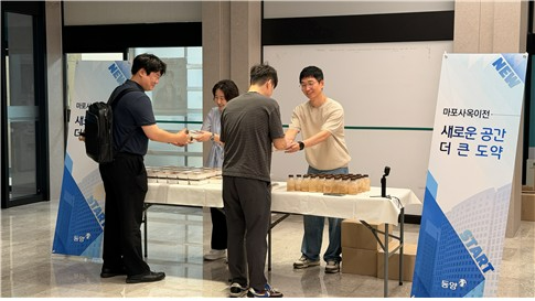 동양이 마포사옥 이전을 기념해 출근하는 임직원들에게 다과를 나눠주고 있다. 사진=유진그룹