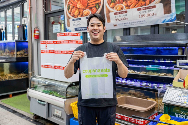 속초관광수산시장 크랩인해담지 사장님이 지원받은 친환경 봉투를 선보이고 있다