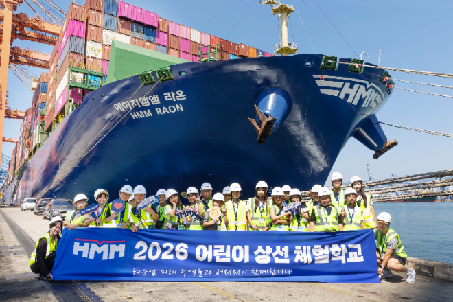 HMM ‘2026 어린이 상선체험’에 참가한 초등학생들이 6일 HMM터미널(HPNT)에서 터미널 견학을 마친 뒤 1만6000TEU급 컨테아너선을 배경으로 기념촬영을 하고 있다. 사진= HMM