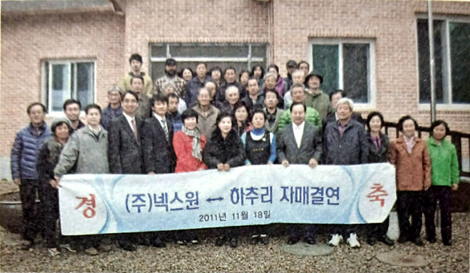 LIG넥스원 임직원들이 2010년 1월 18일 강원도 인제군 하추마을 주민들과 1사1촌 자매결연식을 개최하고 기념촬영을 하고 있다. 사진= LIG D&A