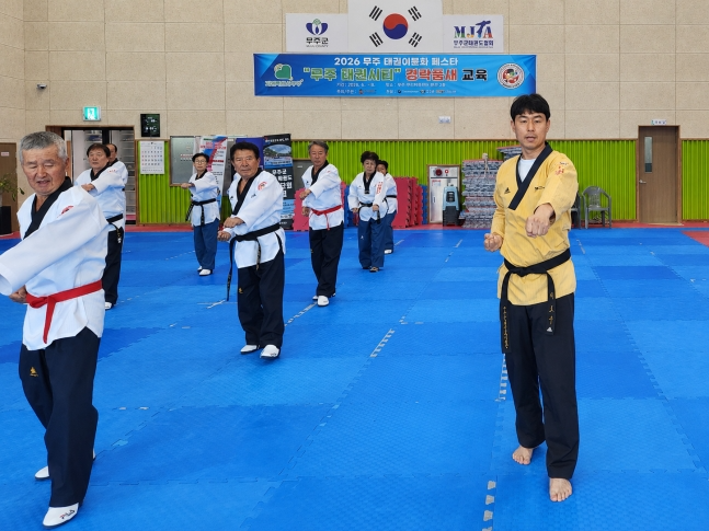 지난 28일 전북 무주국민체육센터에서 이도우(오른쪽) 무주군태권도협회 회장이 경락품세 동작을 시범 보이는 가운데 참가자들이 주먹지르기 자세를 따라 하고 있다. /사진=세계어린이태권도연맹 제공