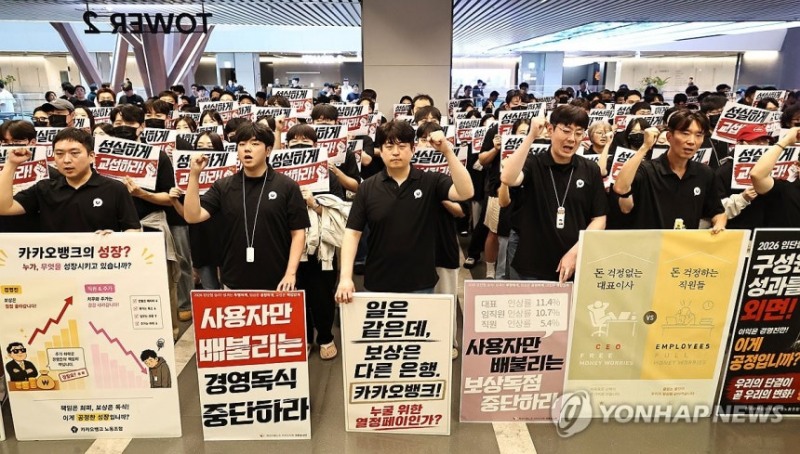 21일 경기도 성남 판교 카카오뱅크 본사 앞에서 카카오 노조원들이 피켓을 들고 구호를 외치고 있다.