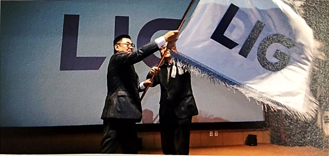 구본상 LIG그룹 회장(왼쪽)이 2021년 11월 2일 열린 비전 선포식에서 직원과 함께 새로운 CI가 적용된 사기를 휘날리고 있다. 사진= KIG D&A
