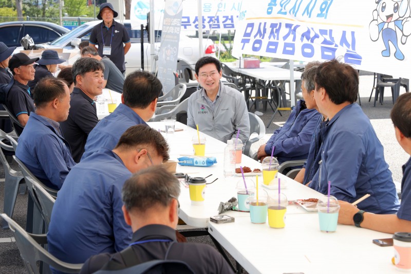 6일 미르스타디움 보조경기장 주차장에서 이상일 시장이 장애인 자동차 무상점검을 하는 조합 관계자들을 격려하고 있다. /용인시