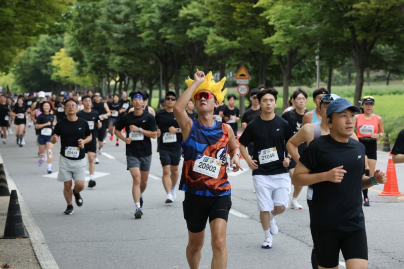 지난 12일 미사경정공원에서 열린 88run 마라톤에서 캐릭터 복장을 한 참가자가 재치있는 동작을 하며 달리고 있다.