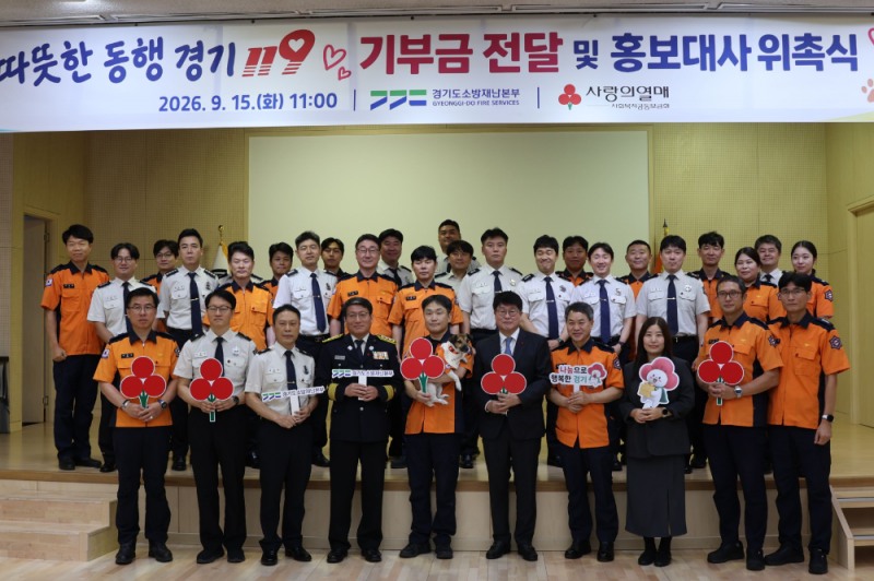 (첫 번째 줄 왼쪽 네 번째부터) 홍장표 경기도소방재난본부장, 신동균 소방위, 반려견 신디, 권인욱 경기 사랑의열매 회장과 경기도소방재난본부 직원들이 기념촬영을 하고 있다.