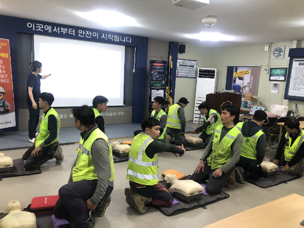 외국인 근로자들이 상황에 맞춰 자동심장충격기(AED)를 사용하고 있다./한화 건설부문