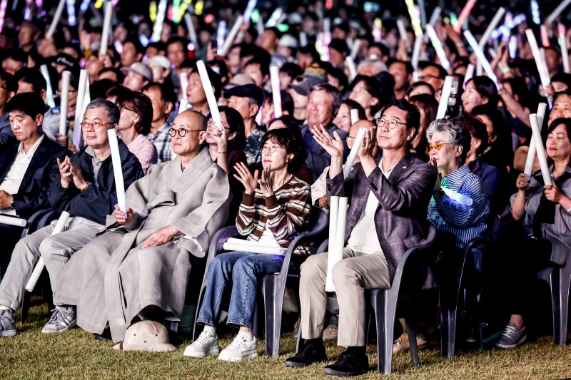 정명근 화성특례시장(맨 앞줄 오른쪽 첫 번째)이 19일 정조효공원에서 열린 2026 병점구 모두의 행복 콘서트에서 시민들과 함께 공연을 관람하며 박수를 치고 있다. /화성시
