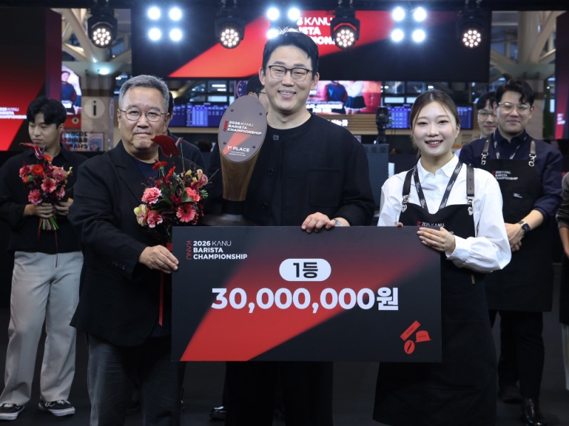 동서식품이 지난 20일 신세계백화점 강남점에서 개최한 ‘2026 카누 바리스타 챔피언십’ 결선 시상식에서 우승자 엄성진 바리스타(가운데), 동서식품 강성룡 마케팅 상무(왼쪽), 작년 대회 우승자 김가은 바리스타(오른쪽)가 기념 촬영을 하고 있다.