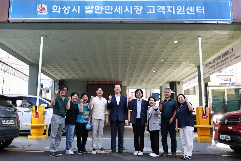 정명근 화성특례시장이 22일 발안만세시장 고객지원센터 앞에서 상인들과 함께 기념촬영을 하고 있다. /화성시