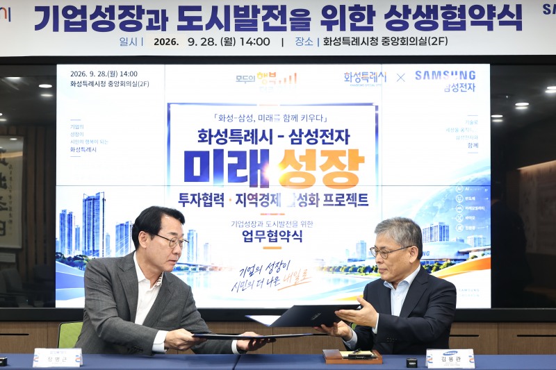 정명근 화성특례시장(왼쪽)과 김용관 삼성전자 DS부문 경영전략총괄 사장(오른쪽)이 미래성장 상생협력 업무협약서에 서명한 뒤 협약서를 교환하고 있다. /화성시