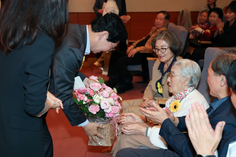 이상일 용인특례시장이 100세를 맞이한 이중희 어르신에게 은수저와 꽃바구니를 전달하고 있다./용인시