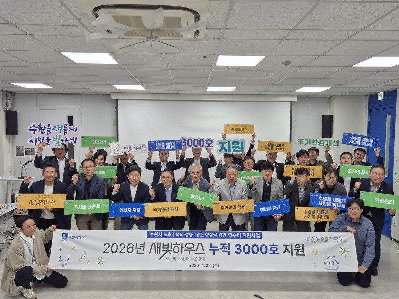 수원도시재단과 집수리 지원사업 관계자들이 새빛하우스 3천호 지원을 기념하는 손팻말을 들고 있다. /수원시
