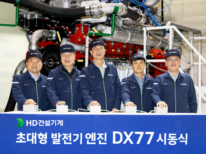 문재영 사장(가운데)을 비롯한 HD건설기계 임직원들이 군산 캠퍼스에서 개최한 DX77 발전용 디젤 엔진 시동식에서 시동을 알리는 버튼을 누르며 기념촬영을 하고 있다. 사진= HD건설기계