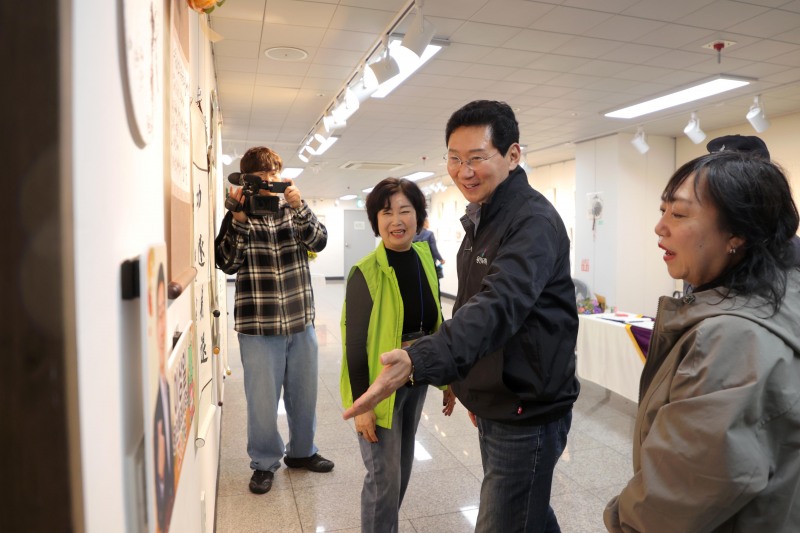이상일 용인특례시장이 18일 수지구 상현2동 ‘제6회 소실봉 문화축제’에서 상현갤러리 수강생의 작품을 살펴보고 있다. /용인시