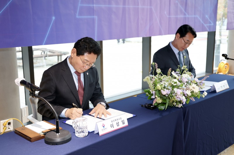 이상일 용인특례시장(왼쪽)과 정명근 화성특례시장(오른쪽)이 19일 남사도서관에서 용인-화성 상생 발전 위한 연계 교통망 구축 협약서에 서명하고 있다. /용인시