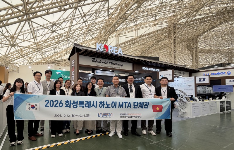‘2026 베트남 하노이 기계전시회’에 참가한 화성시 기업 관계자들이 화성시 단체관 앞에서 기념촬영을 하고 있다./화성시