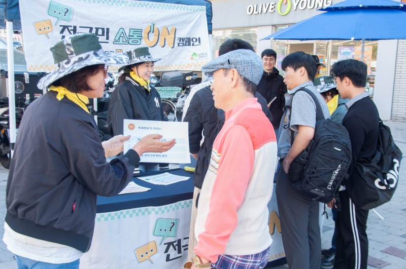 서울 강서구 화곡역 앞에서 열린 ‘전 국민 소통ON 캠페인’에서 봉사자가 시민에게 ‘세대 언어 퀴즈’를 설명하고 있다. 사진 제공=신천지자원봉사단 강서지부