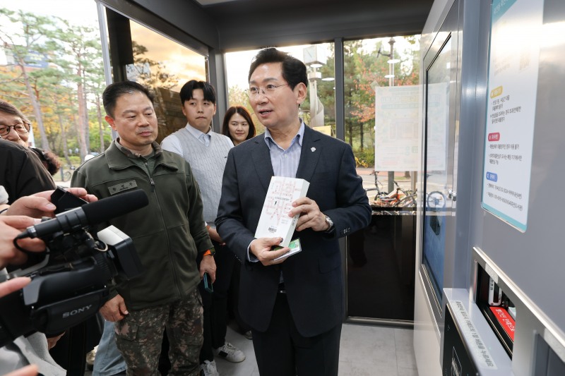 이상일 용인시장이 26일 죽전체육공원 ‘스마트도서관’ 16호점 개관식에서 직접 도서 대출·반납을 시연하며 시설 이용에 불편함은 없는지 살펴보고 있다. /용인시