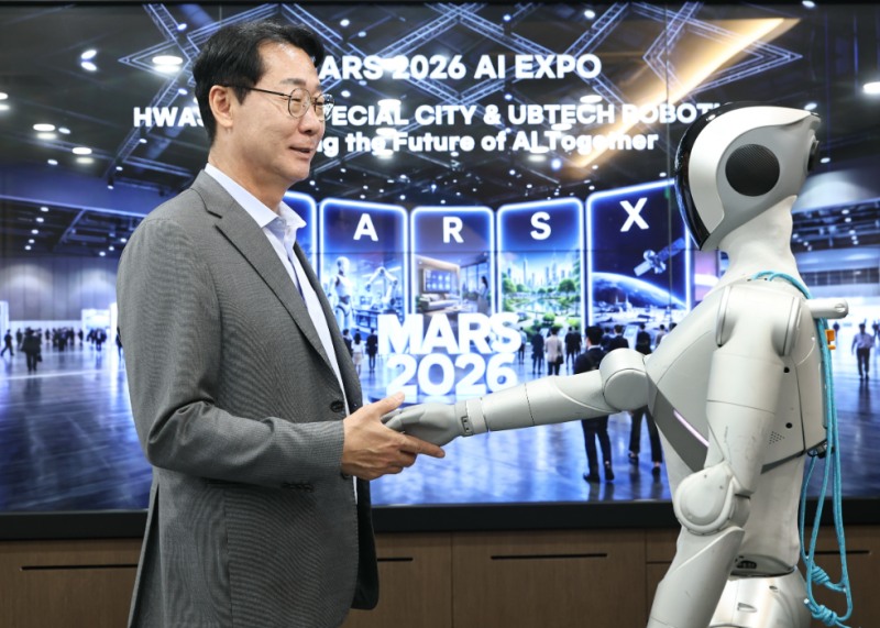 정명근 화성특례시장이 「MARS 2026」 개막식 오프닝 무대에서 발레 퍼포먼스를 선보일 로봇 ‘루나(LUNA)’와 악수를 하고 있다. /화성시