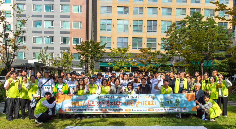 홀트강동복지관이 주최한 제1회 발달장애인 가족 걷기대회 ‘홀·가·분’에 참가한 발달장애인과 가족들이 단체사진을 찍고 있다.