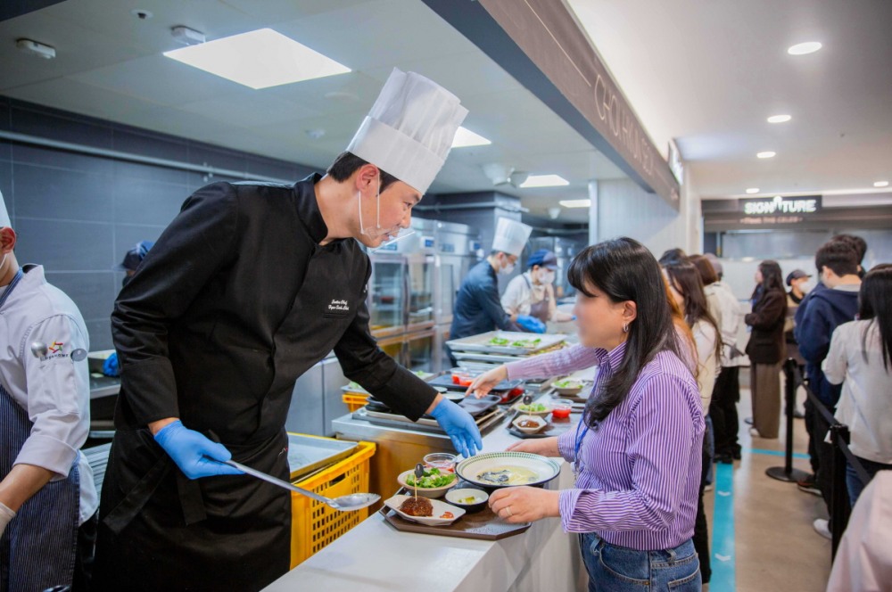 (사진) 19일 포스코타워-송도 사내식당에서 열린 ‘밋더셀럽’ 이벤트에서 최현석 셰프가 임직원들에게 특식을 제공하고 있다.