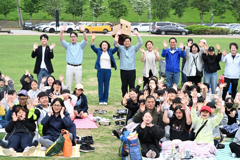 지난 24일, 경기도 시흥시 갯골생태공원에서 열린 ‘제4회 한국지역아동센터연합회(한지연) 시흥지회 가족운동회’에서 아동과 가족, 지역 관계자들이 함께 단체 인사를 하며 환하게 손을 흔들고 있다./사진=시흥시 제공