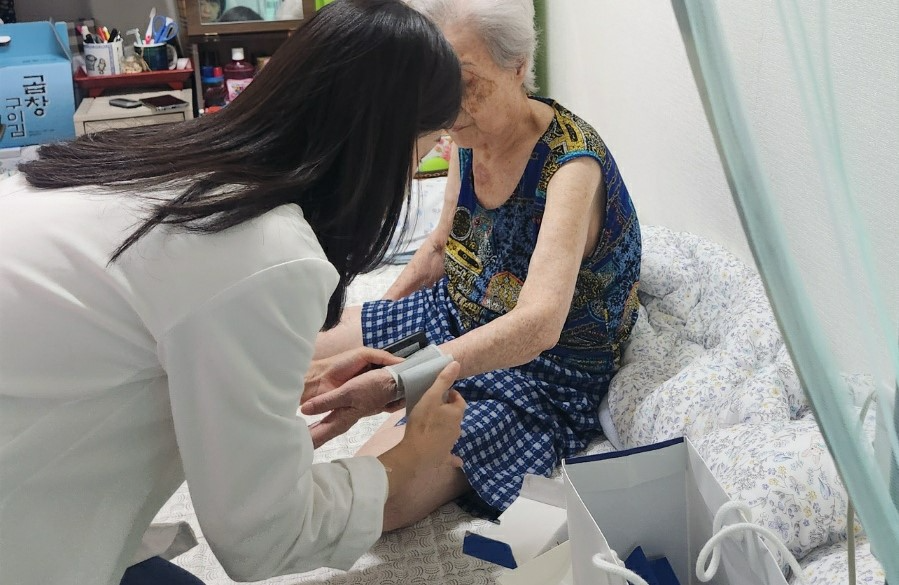 보건 전문가가 지역주민 혈압을 측정 중인 모습