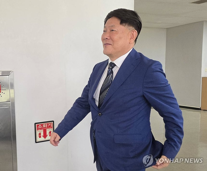 대리점 명의를 위장해 수십억원을 탈세한 혐의로 2심에서 실형을 선고받은 김정규 타이어뱅크 회장이 23일 선고 전 대전고등법원 법정으로 향하고 있다. / 연합뉴스