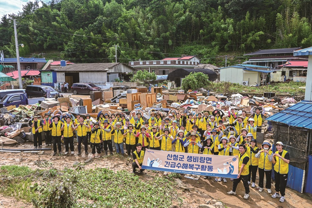 경남권 일대 하나님의 교회 신자들이 산청군 수해복구 활동을 펼치며 구슬땀을 흘렸다. 봉사자들 뒤에 집 밖으로 꺼내진 장롱과 냉장고, 식탁, 장판 등 가재도구와 생필품이 쌓여 있다.