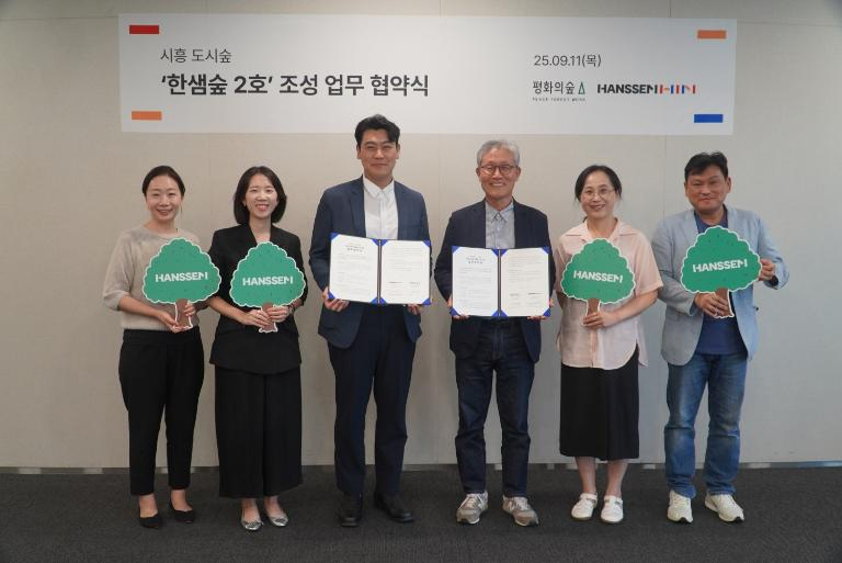 한샘은 경기도 시흥 시화공업단지 인근에 ‘한샘숲 2호’를 조성하기 위해 평화의숲과 업무협약(MOU)을 체결했다. 한샘 정광현 경영지원본부장(가운데 좌측)과 평화의숲 김재현 대표(가운데 우측)가 참석자들과 기념 사진을 촬영하고 있다.