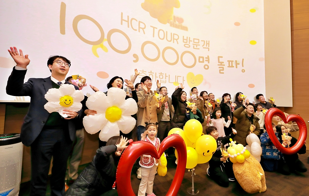 5일 전북 익산 ㈜하림 본사에서 열린 'HCR 투어 누적 방문객 10만 명 돌파 기념행사'에서 하림 임직원들과 당일 방문한 관람객들이 다 함께 손을 흔들며 축하하고 있다.
