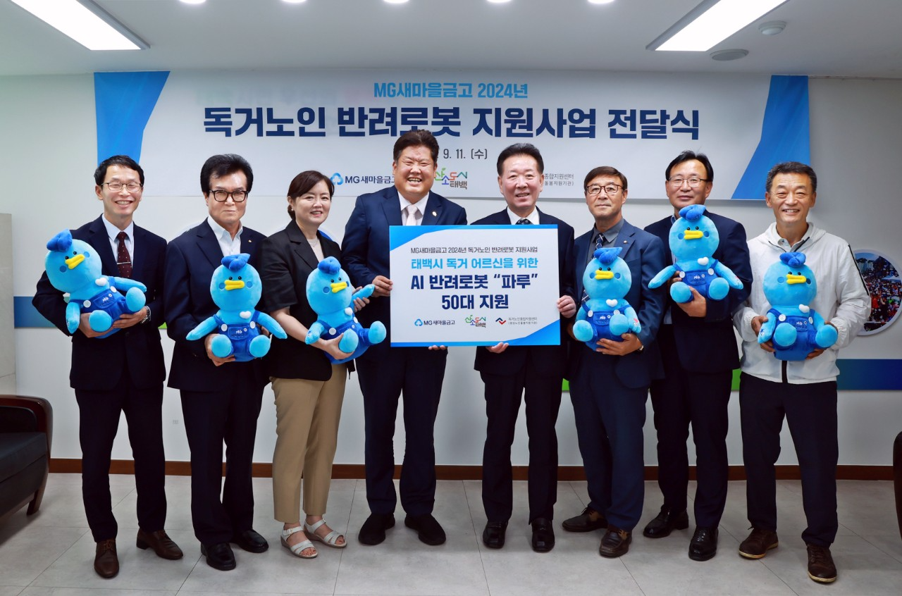 독거노인 위한 생활밀착형 인공지능 반려로봇 전달을 위해 이상호 태백시장(좌측에서 4번째), 한상기 새마을금고중앙회 강원지역이사(좌측에서 5번째), 및 관계자들이 기념촬영을 하고 있다.