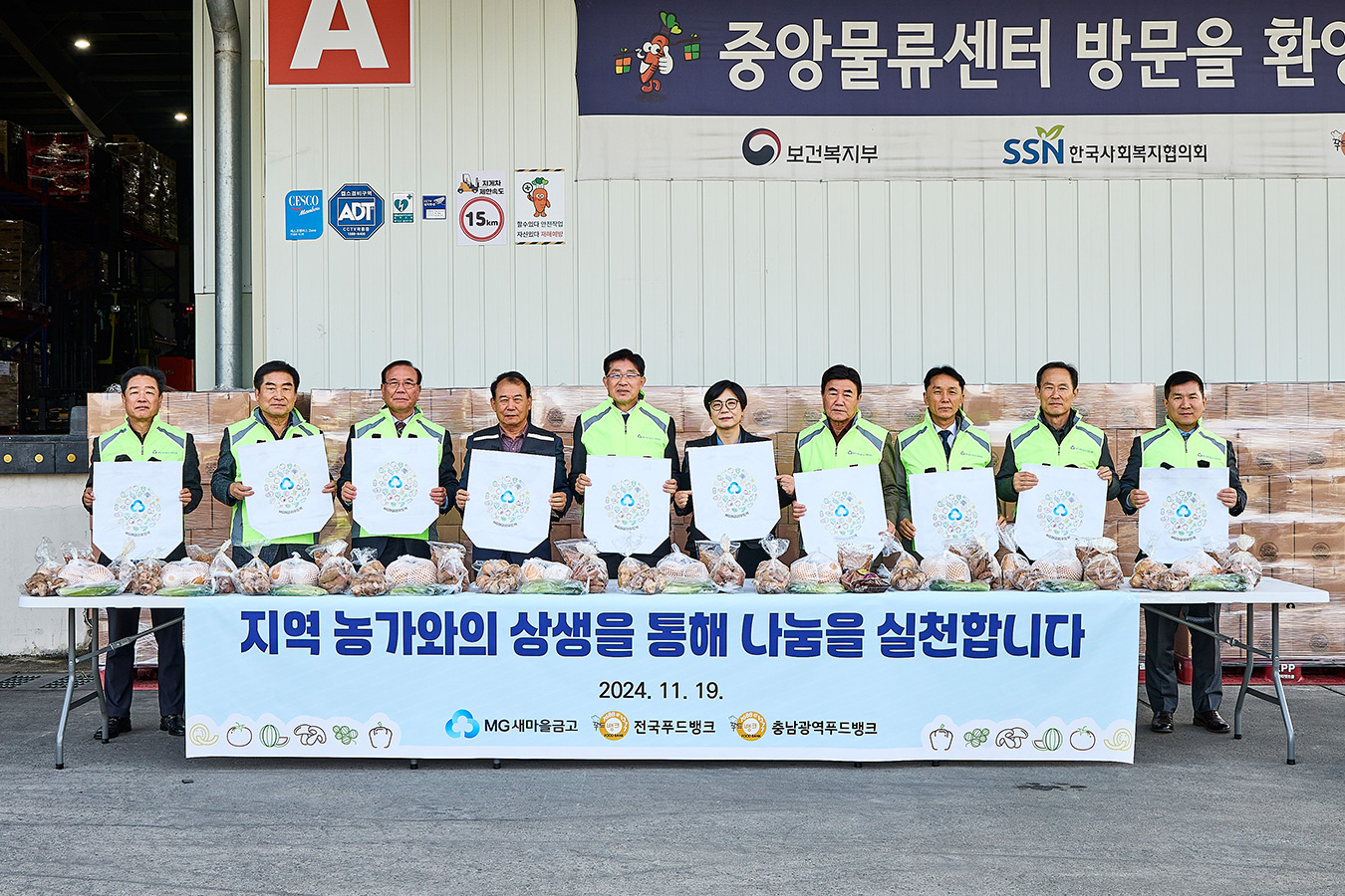 2024.11.19.(화) / 세종특별자치시 전국푸드뱅크 중앙물류센터 (새마을금고중앙회 직원 및 충남지역 관내 새마을금고 이사장, 한국사회복지협의회 푸드뱅크사업 관계자들이 MG어글리푸드 지원사업에 참여하여 기념촬영을 하고 있다)