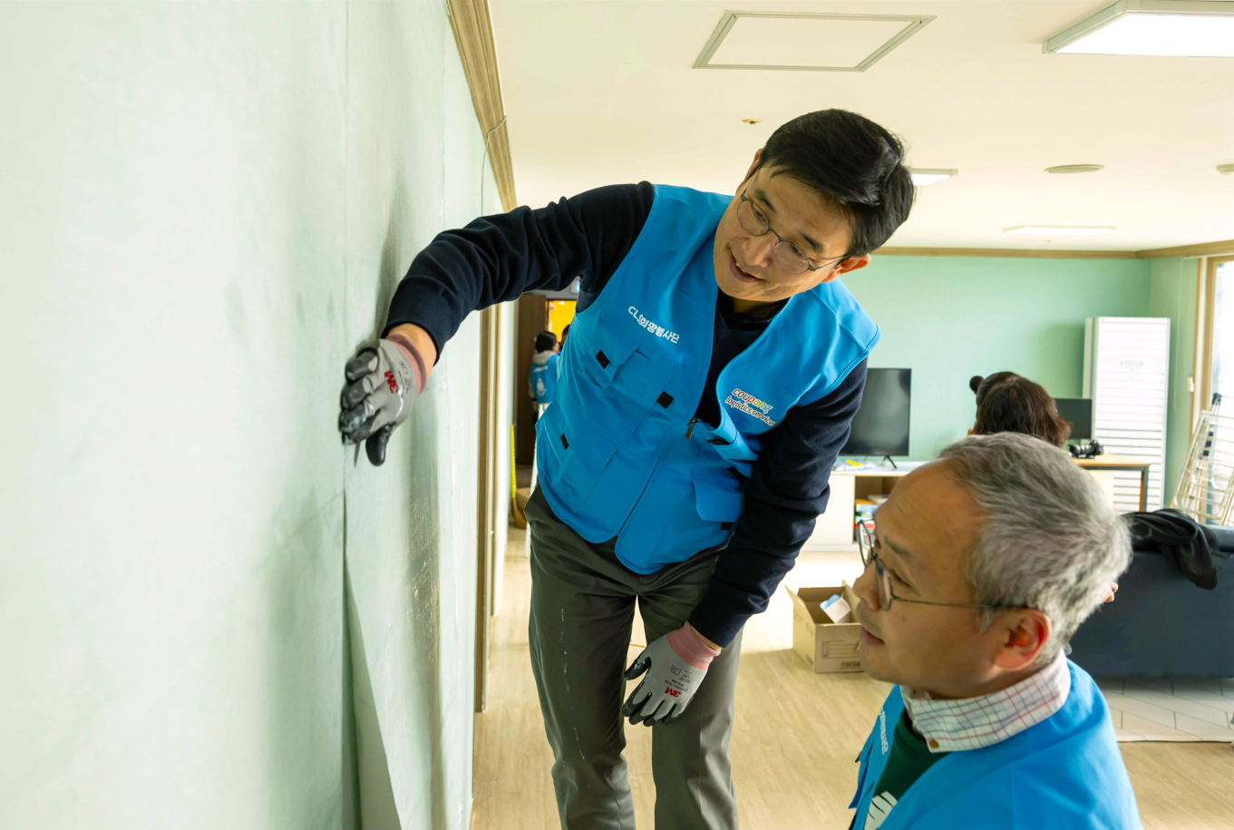 홍용준 쿠팡로지스틱스서비스 대표이사(왼쪽)가 경기도 여주시 아동보육시설 ‘우리집’에서 도배 봉사활동을 하고 있다