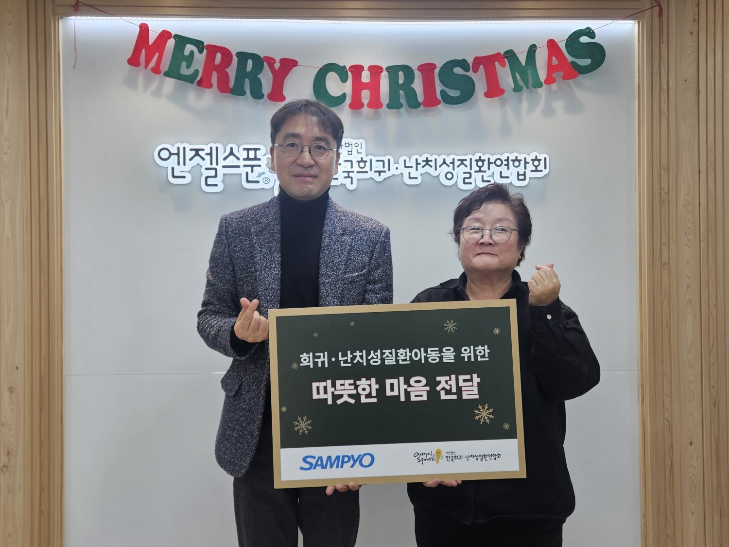 삼표그룹이 크리스마스를 앞두고 희귀질환 아동 가정에 선물을 전달한 가운데 지난 20일 (사)한국희귀난치성질환연합회 사무실에서 유용재 삼표그룹 사회공헌단장과 정진향 (사)한국희귀∙난치성질환연합회 사무총장이 기념촬영을 하고 있다. (사진 제공=삼표그룹)