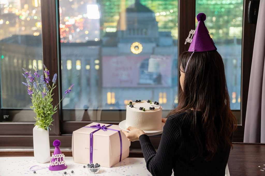 패키지 이용객이 블랑제리 더 플라자의 ‘베리 생크림 케이크’를 들고 있다