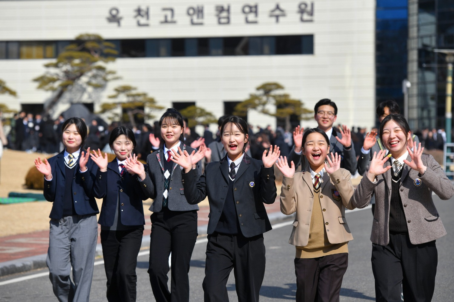 '2025 학생 개학예배'가 열린 하나님의 교회 옥천고앤컴연수원에서 학생들이 밝은 표정으로 손을 흔들고 있다.