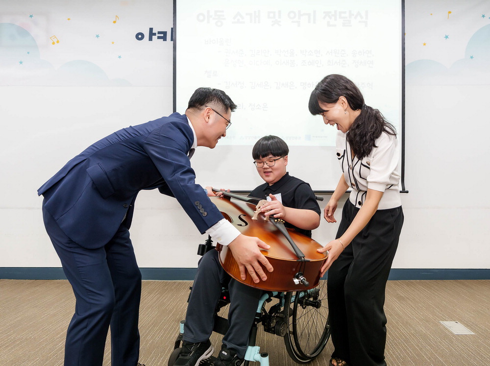 유준원 상상인그룹 대표가 휠체어 사용 아동에게 오케스트라 악기를 수여하고 있다.사진=상상인그룹