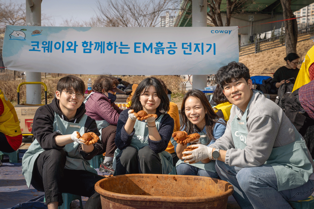 코웨이 임직원 봉사자가 안양천 다목적광장에서 EM 흙공을 제작하고 있다.