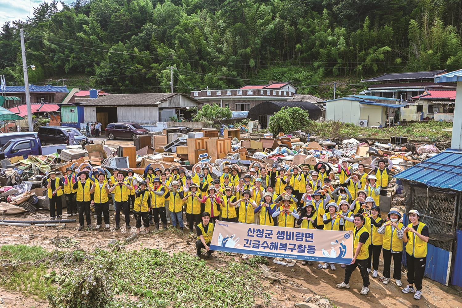 경남권 일대 하나님의 교회 신자들이 산청군 수해복구 활동을 펼치며 구슬땀을 흘렸다. 봉사자들 뒤에 집 밖으로 꺼내진 장롱과 냉장고, 식탁, 장판 등 가재도구와 생필품이 쌓여 있다.