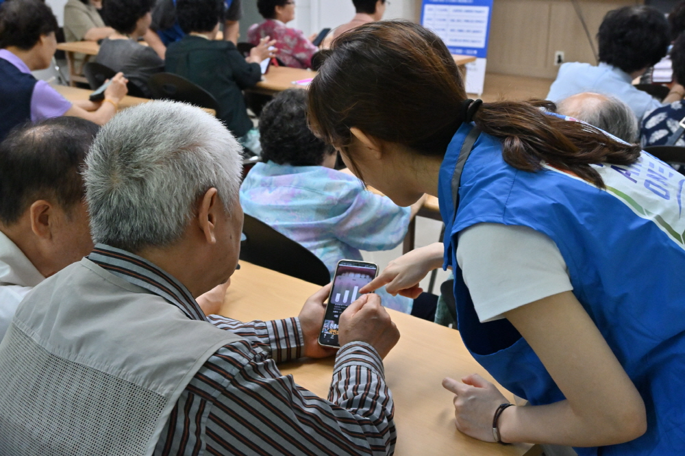 위아원 서울경기서부 지역연합회 영등포지부의 봉사자가 어르신들의 스마트폰 실습을 돕고 있다. (청년자원봉사단 위아원 서울경기서부 지역연합회 영등포지부 제공)