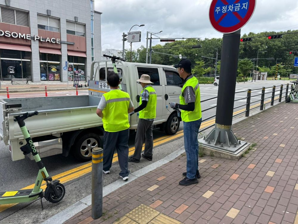 천안시 공무원들이 개인형 이동장치(PM) 지정주차제 시행 이후 무단 방치된 PM을 견인하고 있다.(천안시 제공)