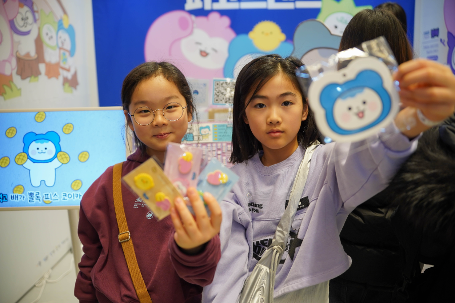 29일 서울 강남구 코엑스에서 열린 ‘K-일러스트레이션페어 서울 2026’ 코이카 피코프렌즈(PeKO Friends) 부스를 방문한 관람객이 이벤트 선물을 받고 즐거워하고 있다.