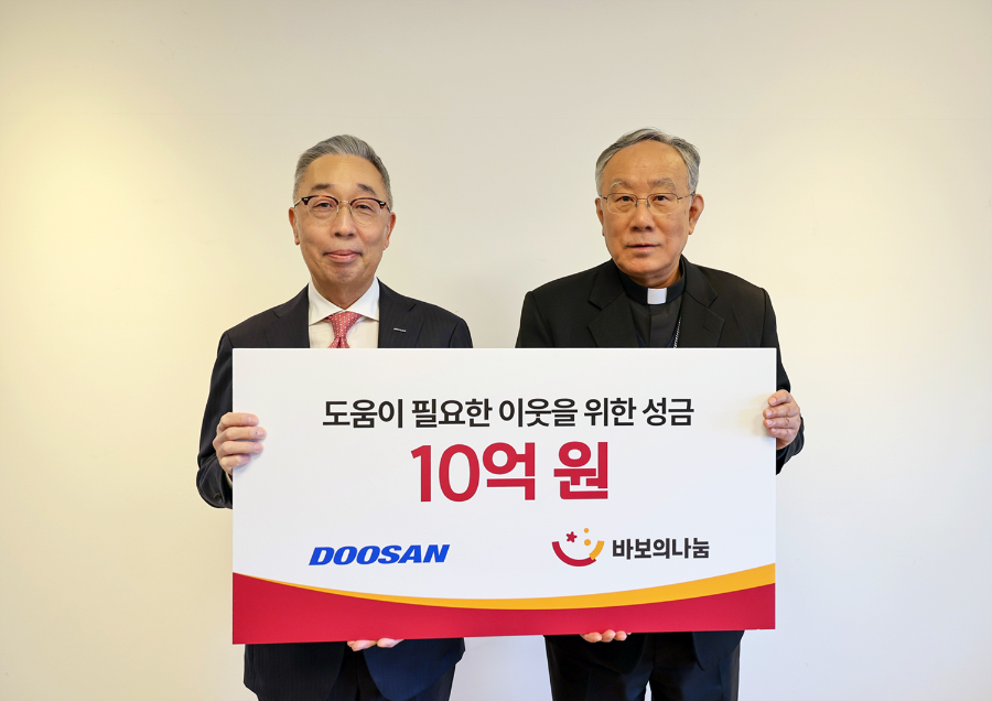 박지원 두산그룹 부회장(사진 왼쪽)과 구요비 재단법인 바보의 나눔 이사장이 3일 서울 명동성당에서 열린 성금 전달식에서 기념촬영을 하고 있다.