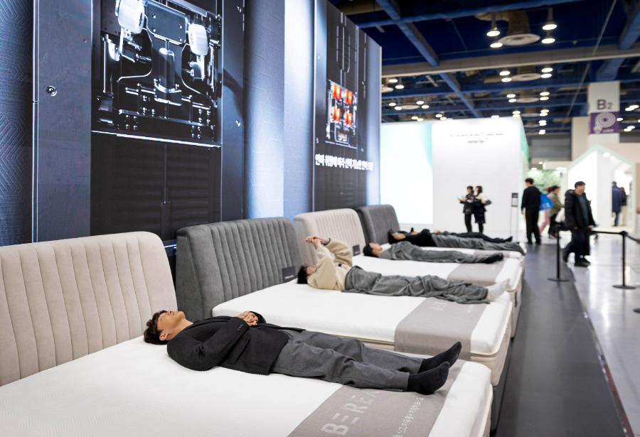 코웨이 ‘비렉스 안마 매트리스 M시리즈’를 체험하는 관람객 모습. 평소에는 안락한 매트리스로 사용하다가 필요시 내장된 히든 안마 모듈이 올라와 강력한 안마를 제공한다.