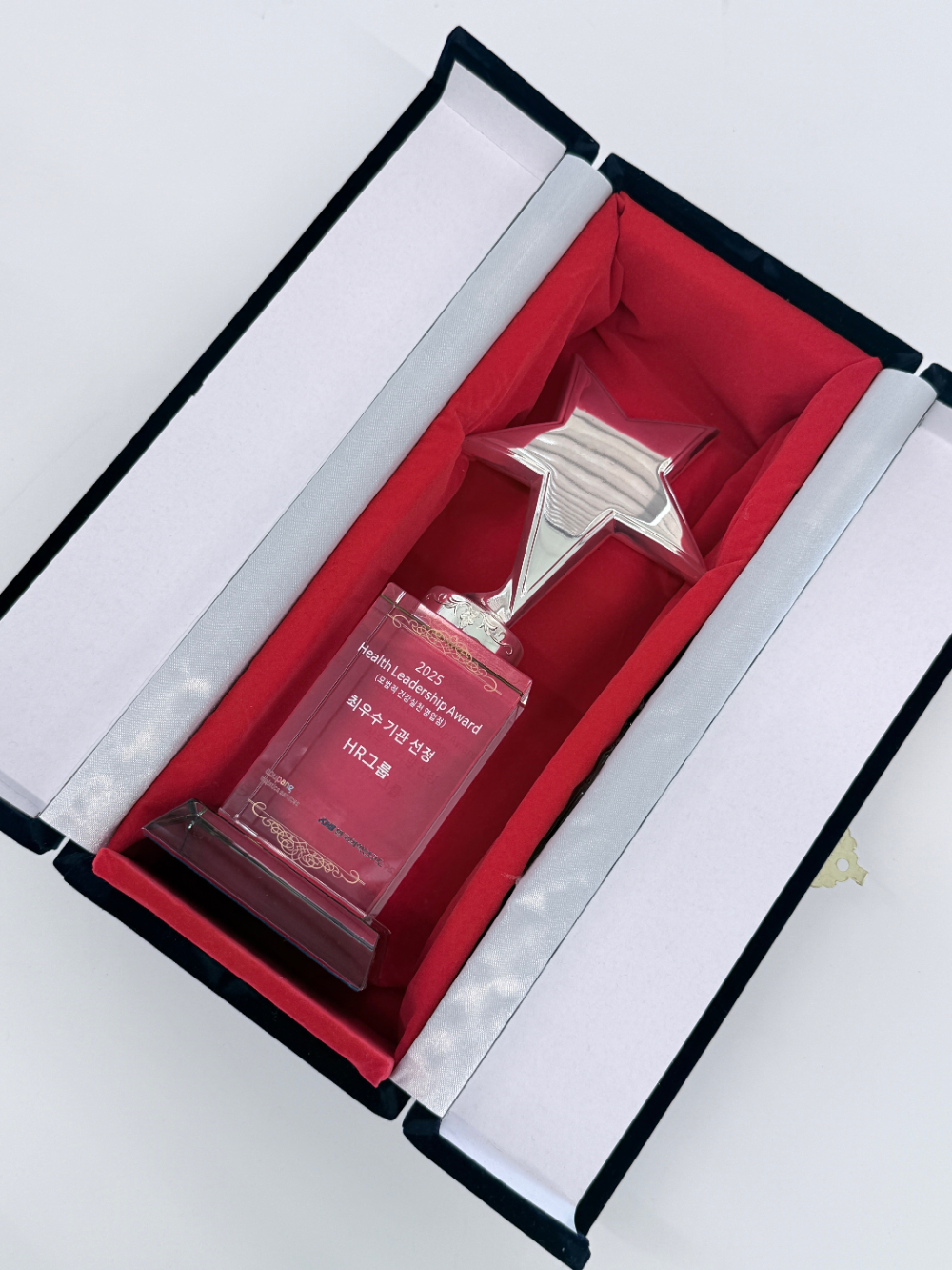 KMI로부터‘2025 모범적 건강 실천 영업점 최우수 기관’으로 선정돼 HR그룹이 수여받은 트로피/사진=HR그룹㈜ 미디어팀 제공